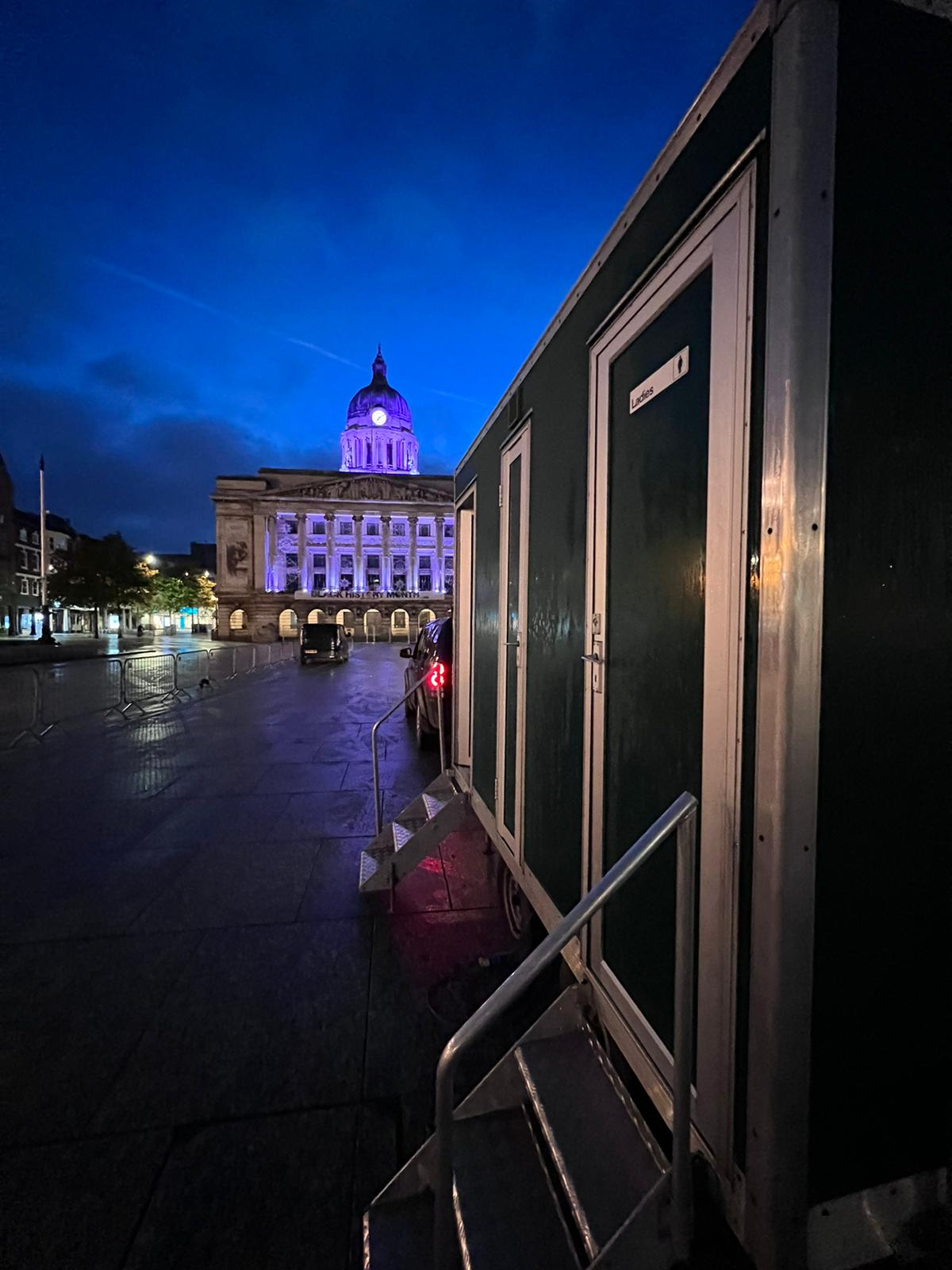 Kniftons luxury toilet trailer in Nottingham's Old Market Square at dusk with the illuminated Council House behind